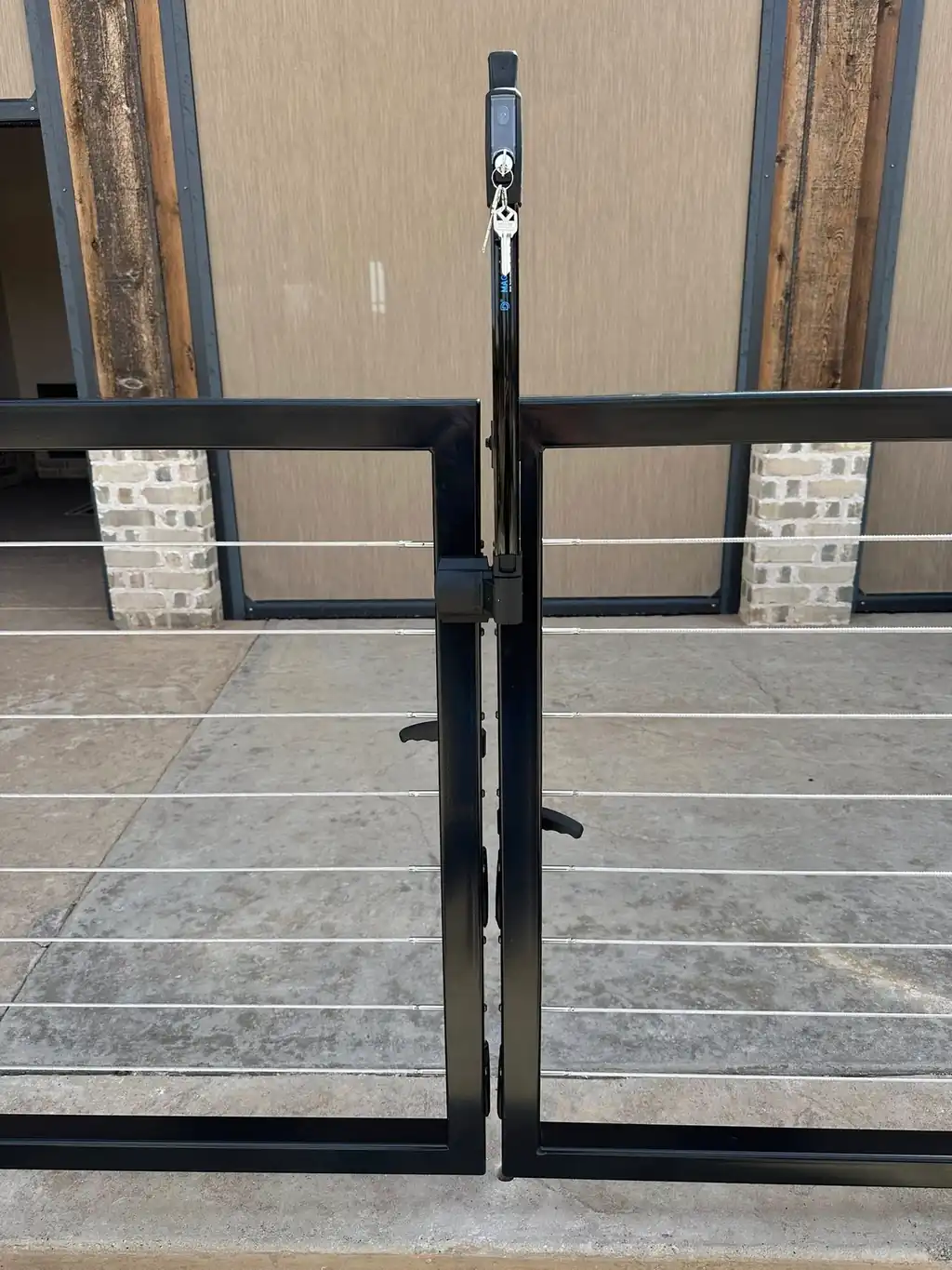 Close detail of a matched pair of cable-rail gates with MagnaLatch hardware
